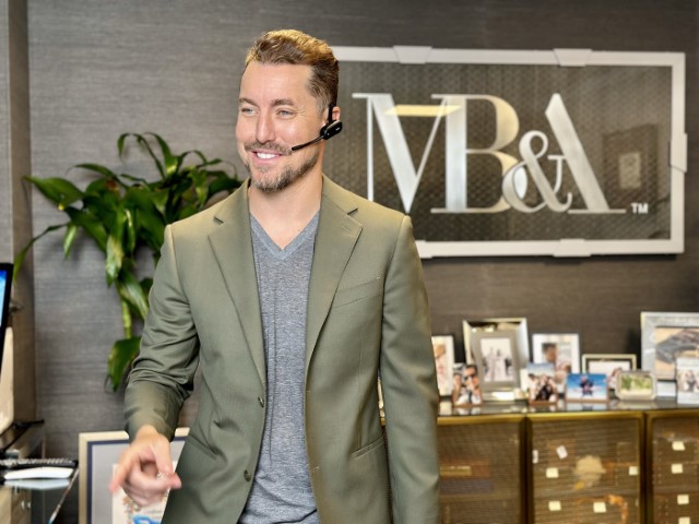 Attorney Michael Burgis in green blazer with headset smiling in MBA branded office ready to assist with wage and hour claims in Sherman Oaks California