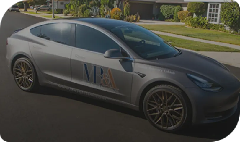 Silver Tesla wrapped with Michael Burgis & Associates branding and Recovery for the Injured® tagline parked to support California workers' compensation clients