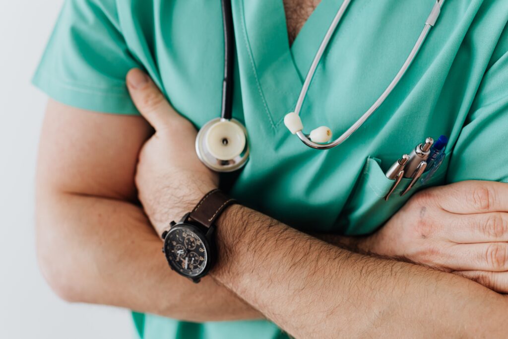 Confident doctor or nurse in green scrubs with arms crossed and stethoscope representing medical care for catastrophic injuries in Sherman Oaks California