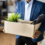 A man who was the only person laid off leaves his office.